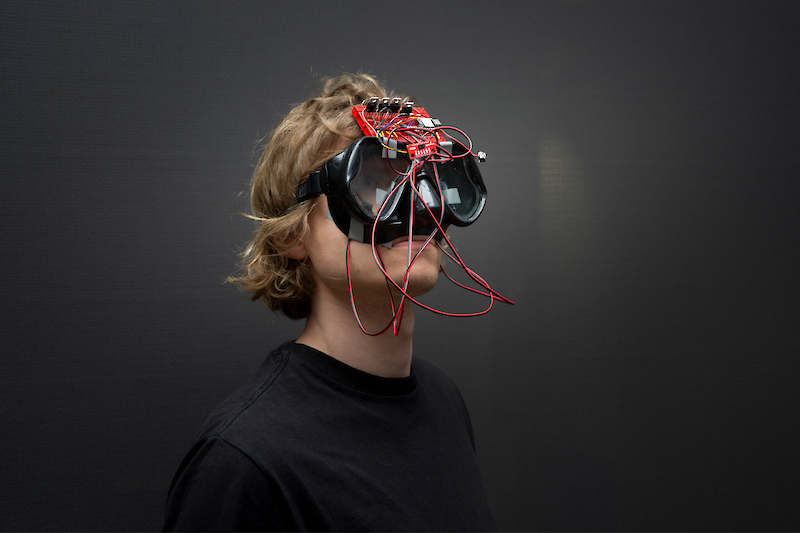 Turbid Encounters || Carlo Hatke & Wangqing Li || Turbid Encounters translates the movement and proximity of surrounding bodies and objects into vibrations across the face. A wearable mask suspends visual orientation, shifting perception into air as a dense relational medium where co-presence unfolds as turbid patterns of motion.