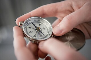 Person holding a compass in their hands.